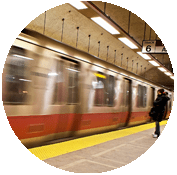 A train is moving down the tracks at a station.